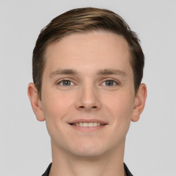 Joyful white young-adult male with short  brown hair and grey eyes