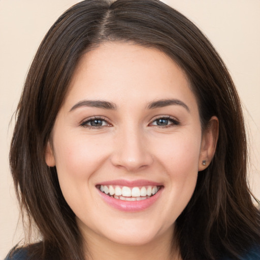 Joyful white young-adult female with long  brown hair and brown eyes