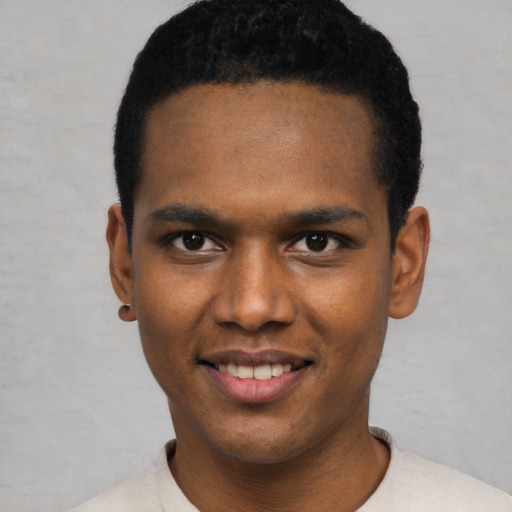 Joyful black young-adult male with short  black hair and brown eyes