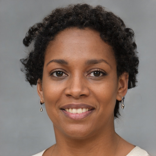 Joyful black young-adult female with short  brown hair and brown eyes