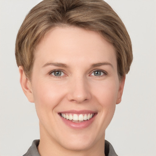 Joyful white young-adult female with short  brown hair and grey eyes