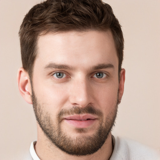 Joyful white young-adult male with short  brown hair and grey eyes