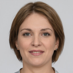 Joyful white adult female with medium  brown hair and grey eyes