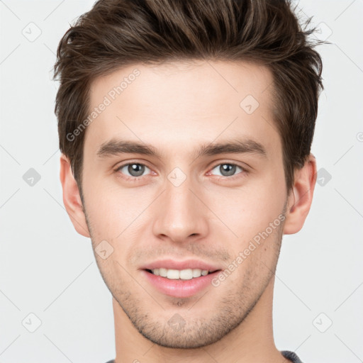 Joyful white young-adult male with short  brown hair and grey eyes