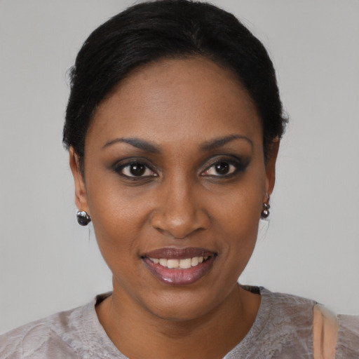 Joyful black young-adult female with short  black hair and brown eyes