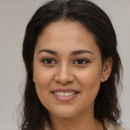 Joyful latino young-adult female with long  brown hair and brown eyes