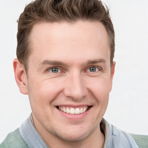 Joyful white young-adult male with short  brown hair and grey eyes