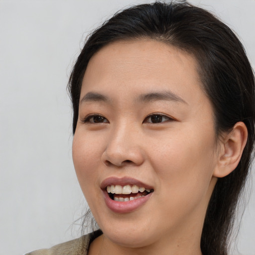 Joyful asian young-adult female with medium  brown hair and brown eyes
