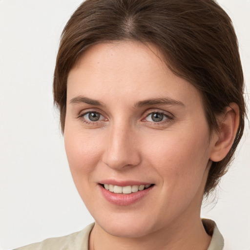 Joyful white young-adult female with medium  brown hair and grey eyes