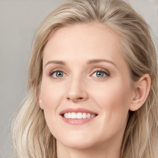 Joyful white young-adult female with long  brown hair and blue eyes