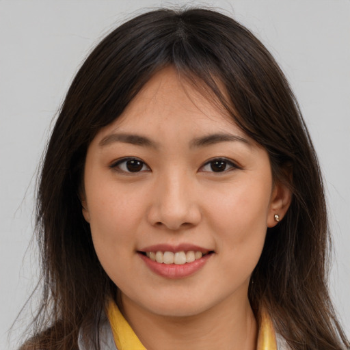 Joyful asian young-adult female with long  brown hair and brown eyes