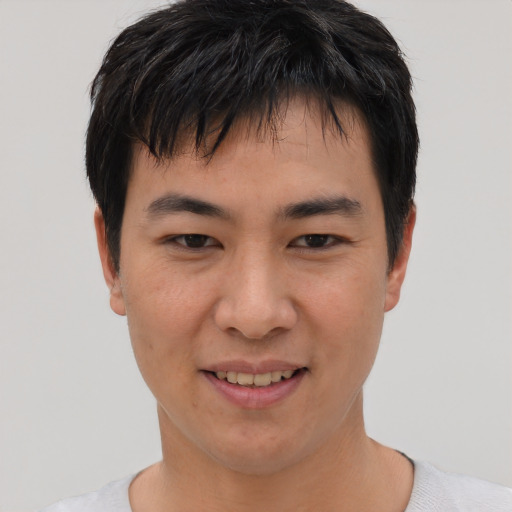 Joyful asian young-adult male with short  black hair and brown eyes