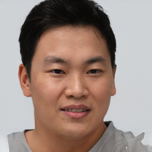Joyful asian young-adult male with short  brown hair and brown eyes