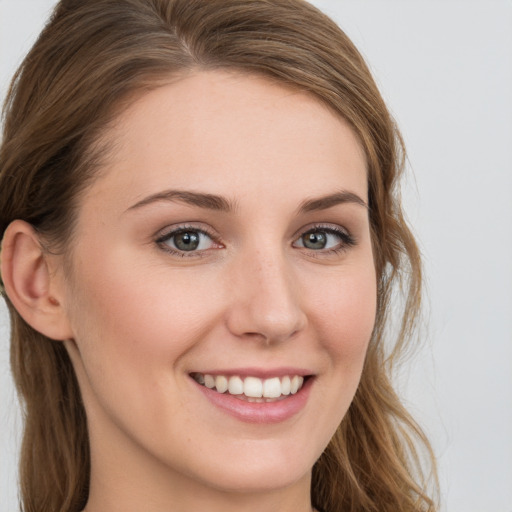 Joyful white young-adult female with long  brown hair and blue eyes