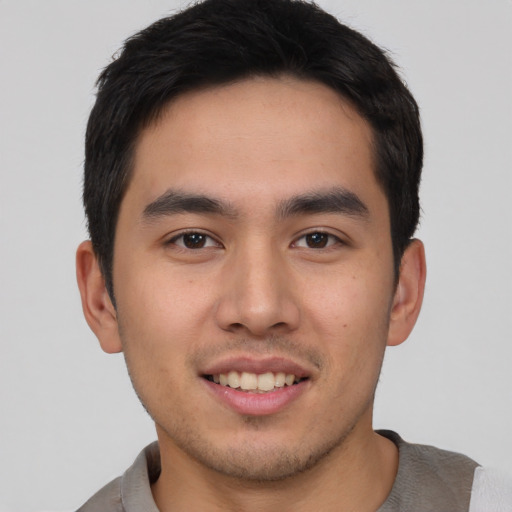 Joyful asian young-adult male with short  brown hair and brown eyes