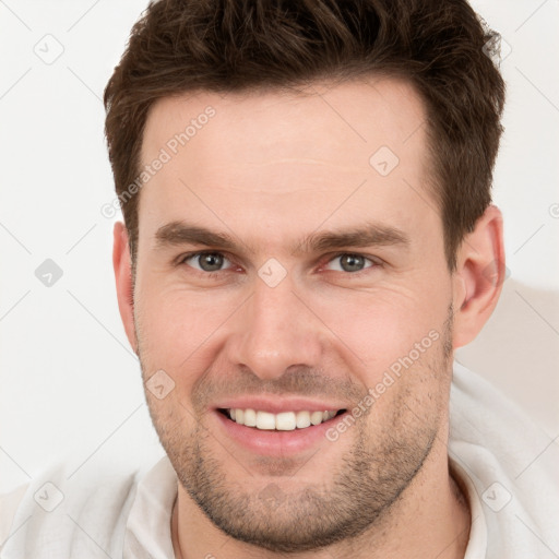 Joyful white young-adult male with short  brown hair and brown eyes