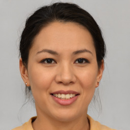 Joyful asian young-adult female with medium  brown hair and brown eyes