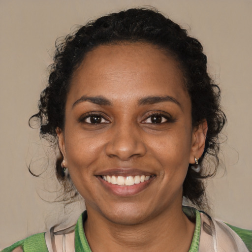 Joyful black young-adult female with short  black hair and brown eyes