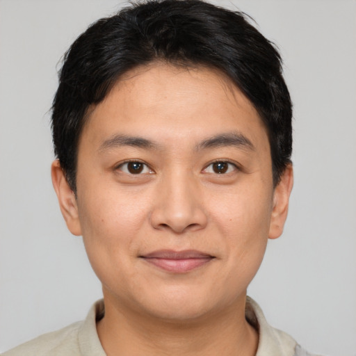 Joyful latino young-adult male with short  brown hair and brown eyes