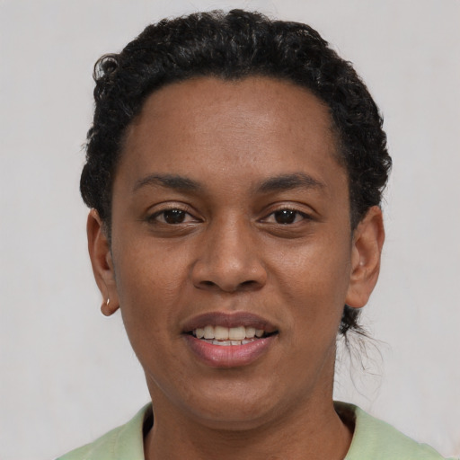 Joyful black young-adult female with short  black hair and brown eyes
