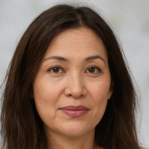 Joyful white adult female with long  brown hair and brown eyes