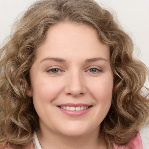 Joyful white young-adult female with long  brown hair and green eyes