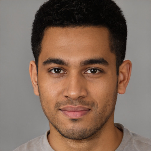 Joyful latino young-adult male with short  brown hair and brown eyes