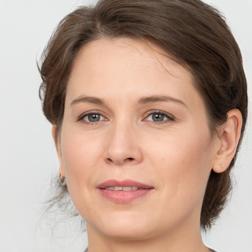 Joyful white adult female with medium  brown hair and grey eyes