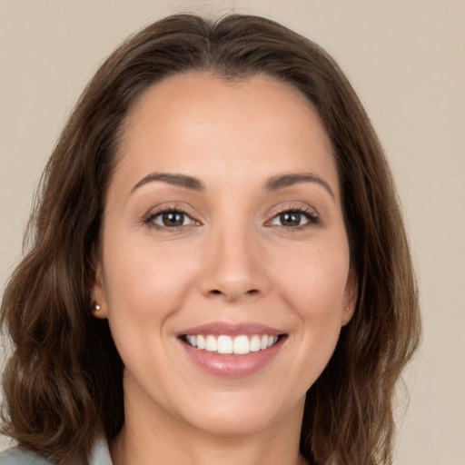 Joyful white young-adult female with long  brown hair and brown eyes