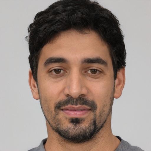 Joyful white young-adult male with short  black hair and brown eyes
