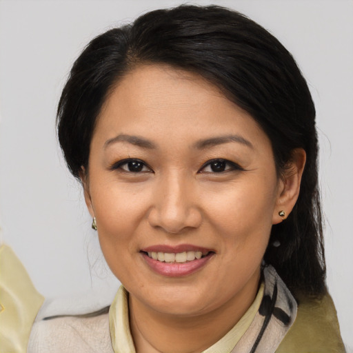 Joyful asian adult female with medium  brown hair and brown eyes