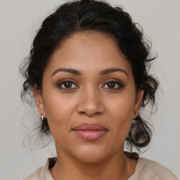 Joyful latino young-adult female with medium  brown hair and brown eyes