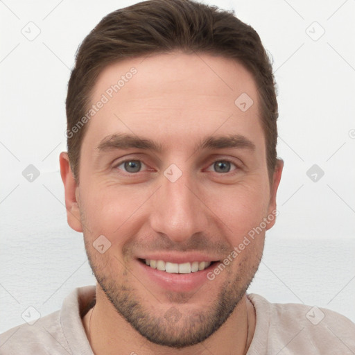 Joyful white young-adult male with short  brown hair and grey eyes