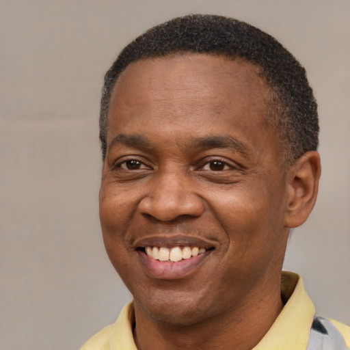 Joyful black adult male with short  brown hair and brown eyes