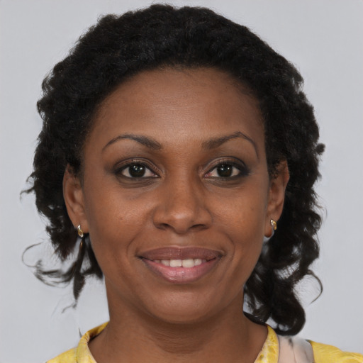 Joyful black adult female with medium  brown hair and brown eyes