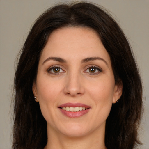 Joyful white adult female with long  brown hair and brown eyes