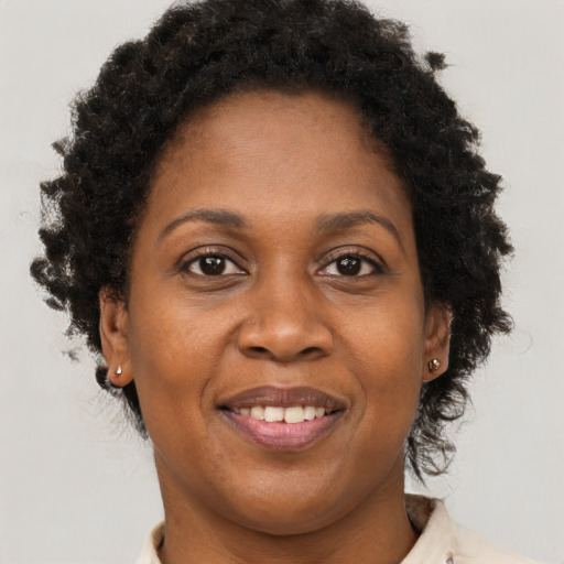Joyful black adult female with short  brown hair and brown eyes
