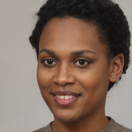 Joyful black young-adult female with short  brown hair and brown eyes