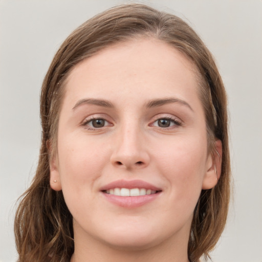 Joyful white young-adult female with medium  brown hair and grey eyes