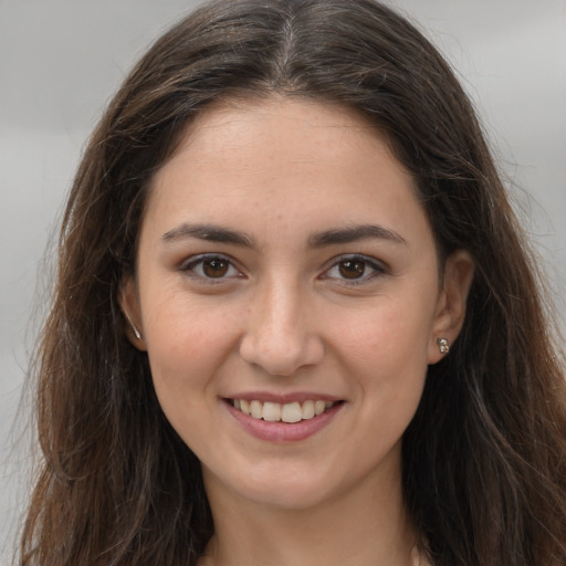 Joyful white young-adult female with long  brown hair and brown eyes