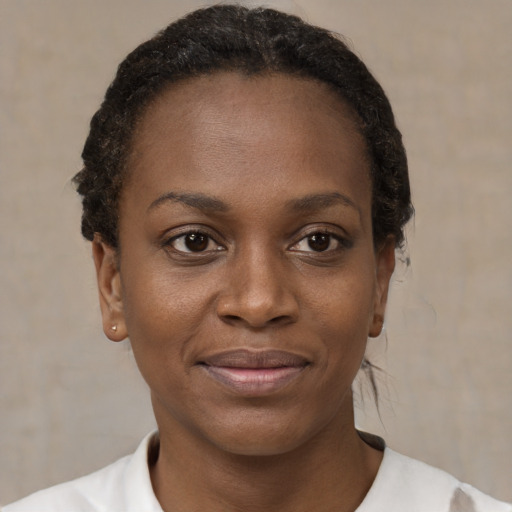 Joyful black young-adult female with short  brown hair and brown eyes