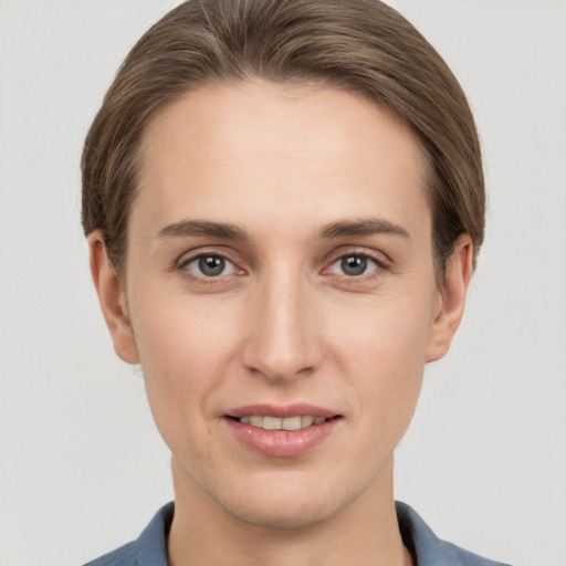 Joyful white young-adult female with short  brown hair and grey eyes