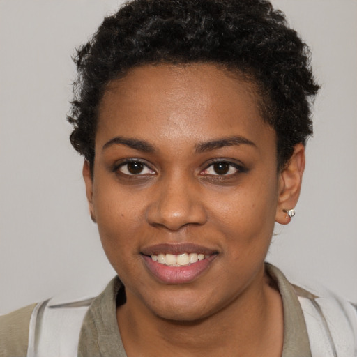 Joyful black young-adult female with short  brown hair and brown eyes