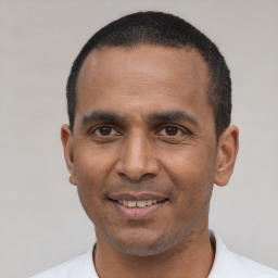 Joyful latino adult male with short  black hair and brown eyes