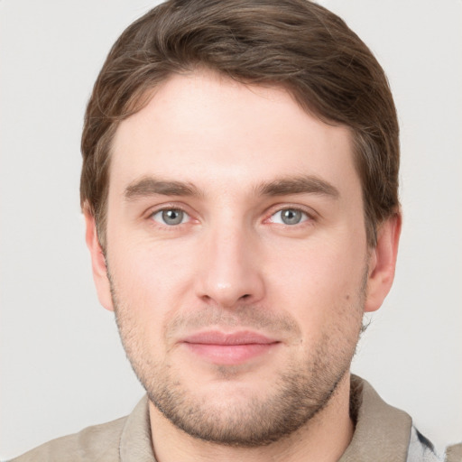 Joyful white young-adult male with short  brown hair and grey eyes