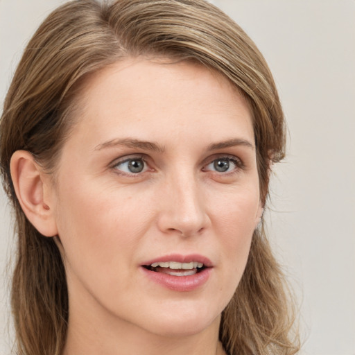 Joyful white young-adult female with long  brown hair and blue eyes