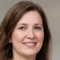 Joyful white adult female with long  brown hair and brown eyes