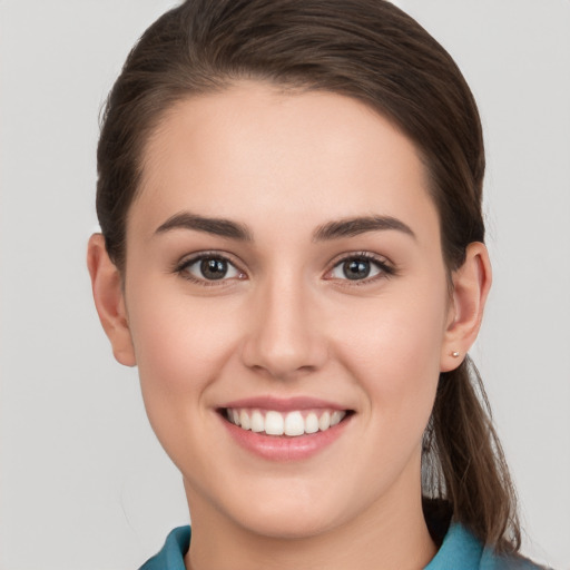 Joyful white young-adult female with short  brown hair and grey eyes