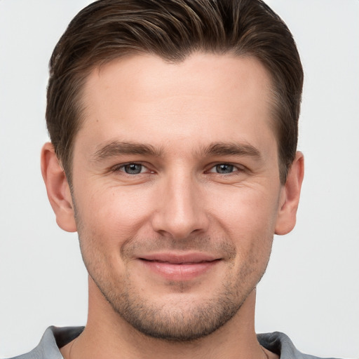 Joyful white young-adult male with short  brown hair and grey eyes