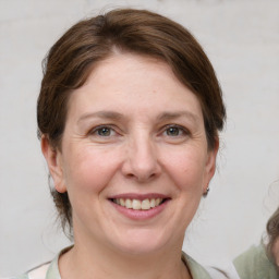 Joyful white adult female with medium  brown hair and grey eyes